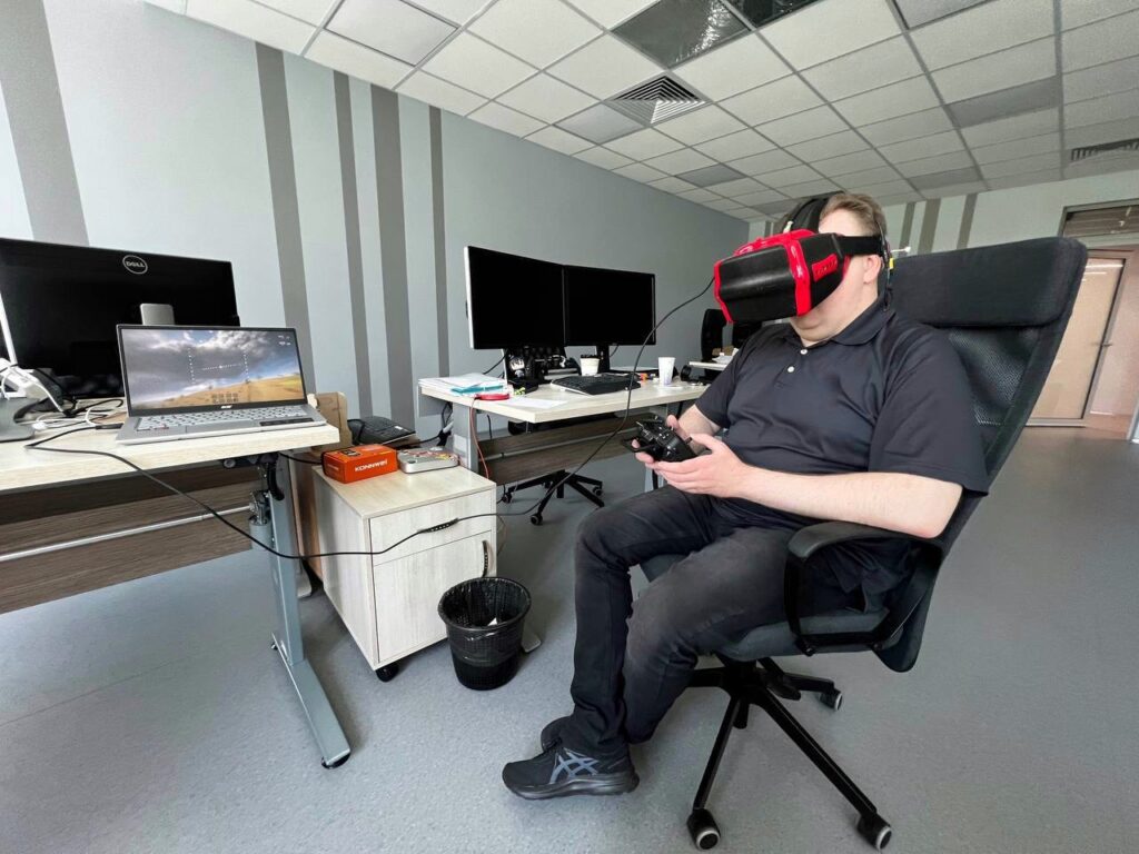 Тестування VR в офісі: людина в шоломі віртуальної реальності з контролером у кріслі.