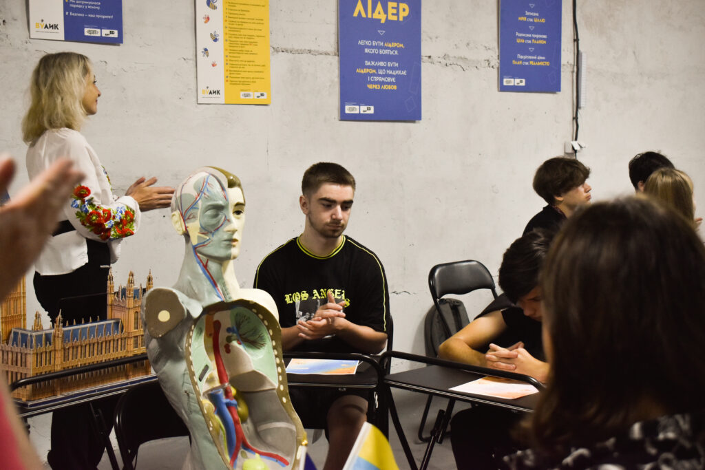 Заняття в укритті школи: учні та вчитель поруч із навчальним анатомічним макетом у центрі savED та EPAM.
