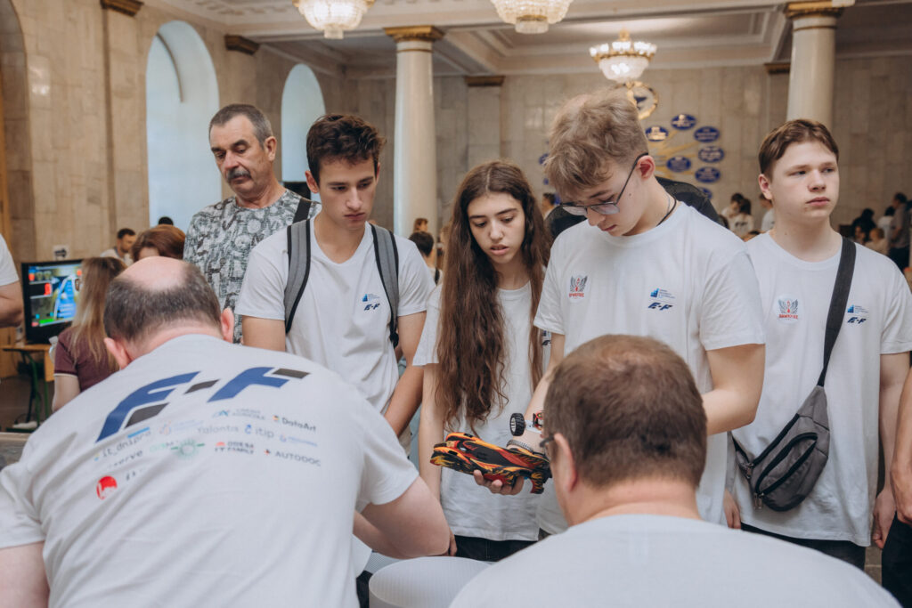 Учасники E-Formula DniproTech досліджують робомашину під час виставки проєктів