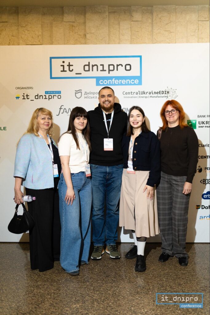 Учасники та партнери IT Dnipro Conference 2025 біля офіційної бренд-стіни заходу.